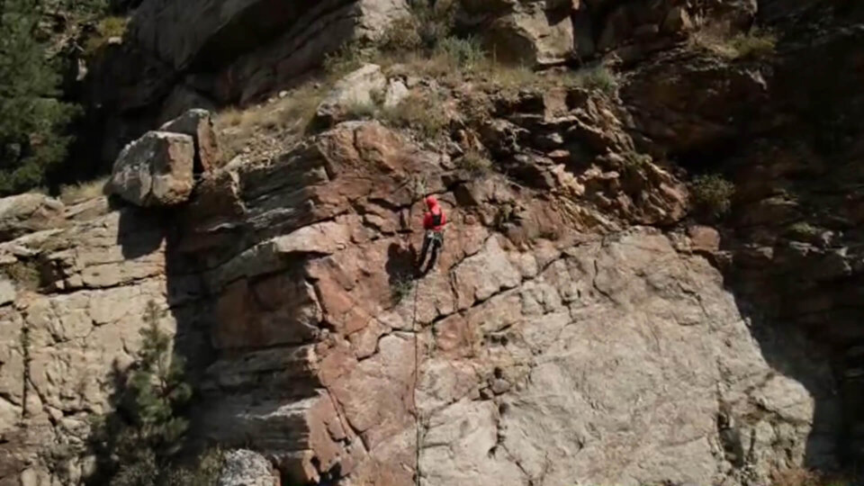 Kevin rappelling down a clif