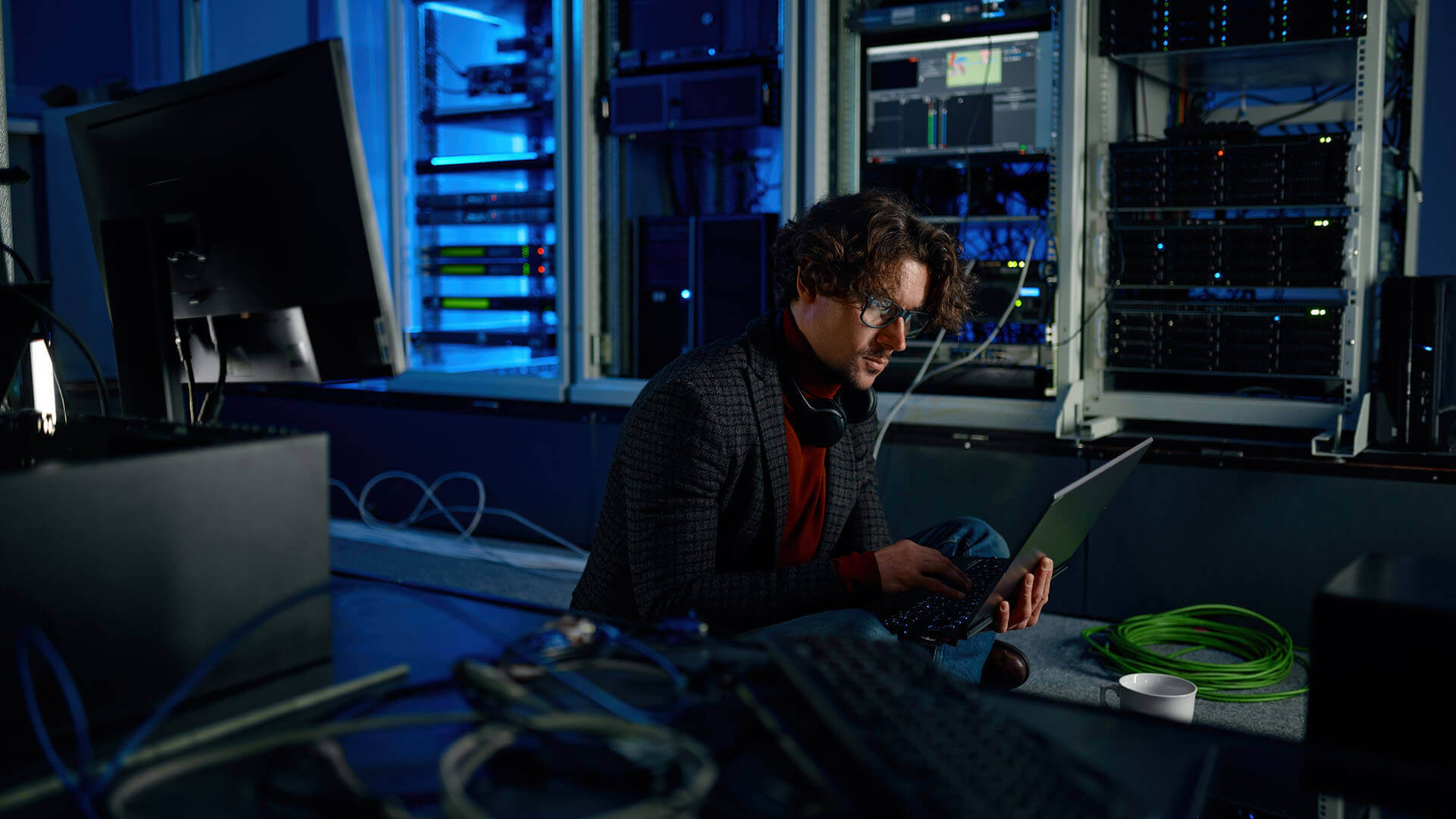 Man Working on Laptop in a Server Room